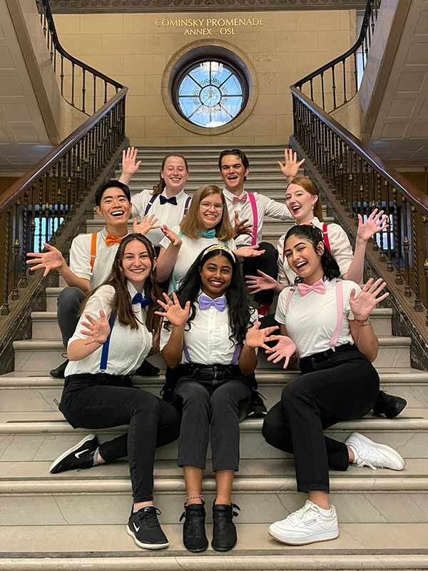 A group of club members sitting on stairs.
