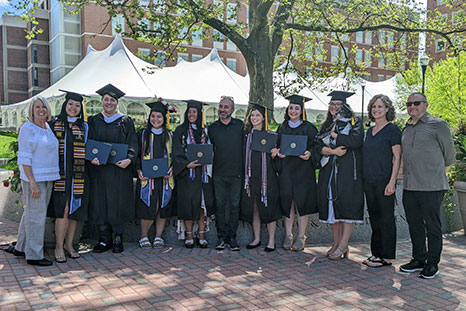 A group photo of faculty and students at commencement.