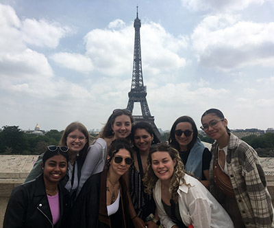 A group of students posing in front of the Eiffel Tower in Paris, France.