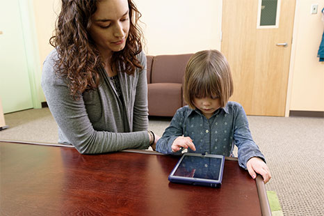 Graduate student with child looking at a tablet