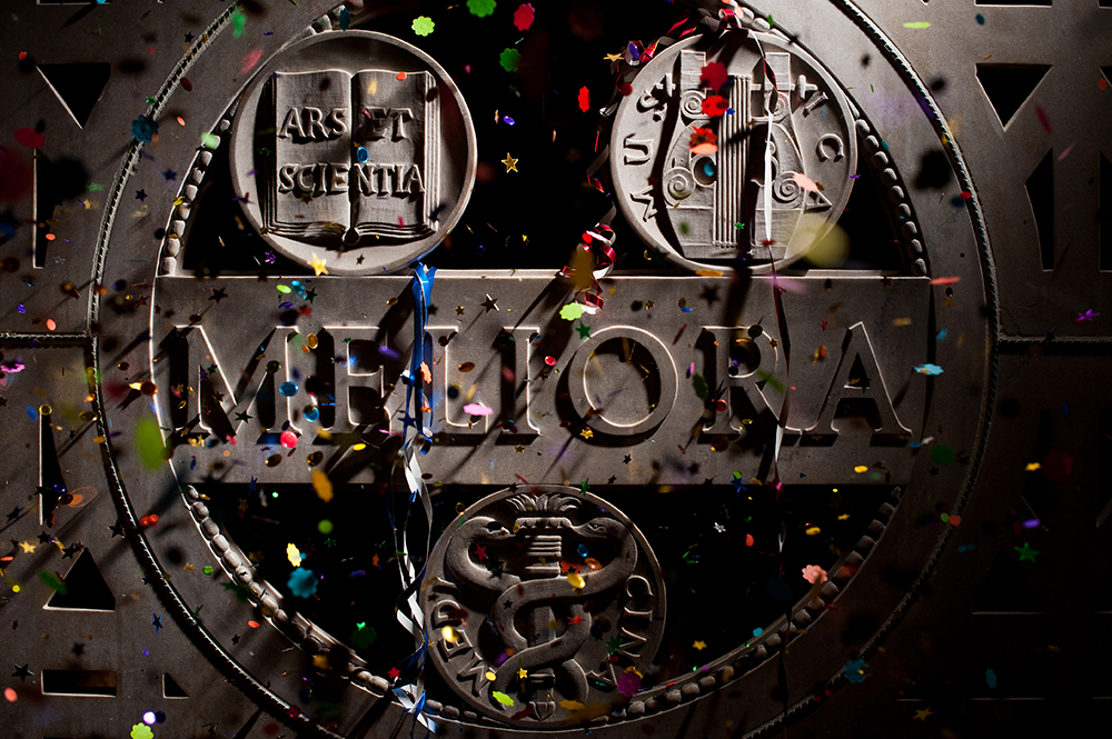 A marble Meliora panel with confetti falling in front of it.