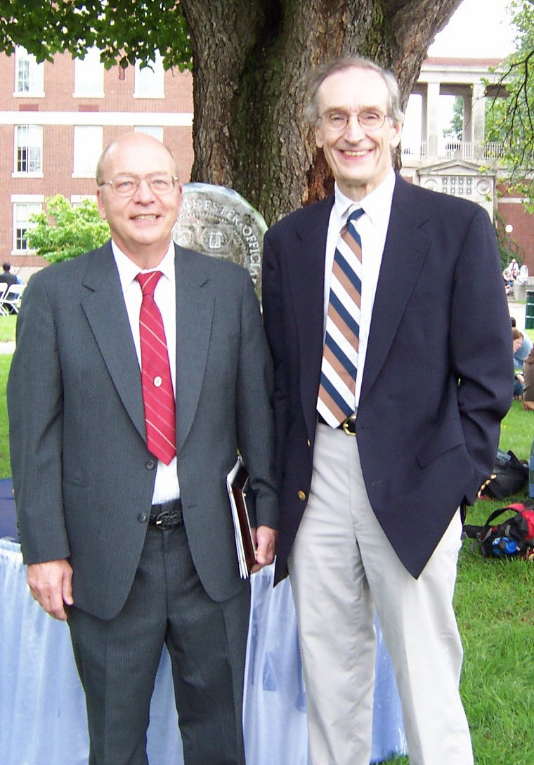 Two people standing in front of a tree smiling at the camera.