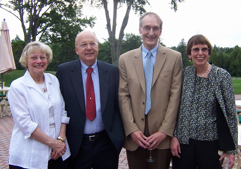 Four people in a group smiling at the camera.