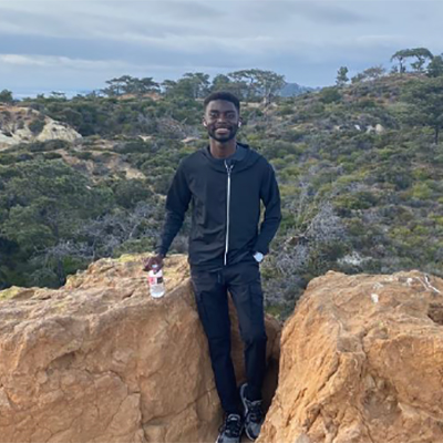 Daniel smiling at the camera with a vista in the background.