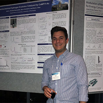 José L. Álvarez-Hernández standing with in front of a poster presentation.