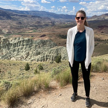 Kaelyn McFarlane Connelly standing with a view of mountains.