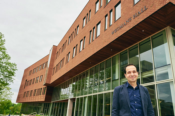 Mujdat Cetin poses in front of Wegmans Hall on the River Campus.