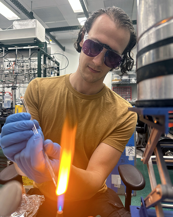 Sebastian working in the lab with an open flame.