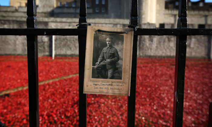 A photograph of Corporal Thomas William Belton, who died in Belgium in World War I at age 25, is placed on the railings surrounding the staging of “Blood Swept Lands and Seas of Red” at the Tower of London. The artistic installation featured 888,246 handmade ceramic poppies, each representing a British or colonial soldier killed during the Great War. In Posthumous Lives: World War I and the Culture of Memory, University of Rochester professor Bette London take a closer look at this and other commemorative activities as a British national practice and pastime. (Getty Images / Peter Macdiarmid)