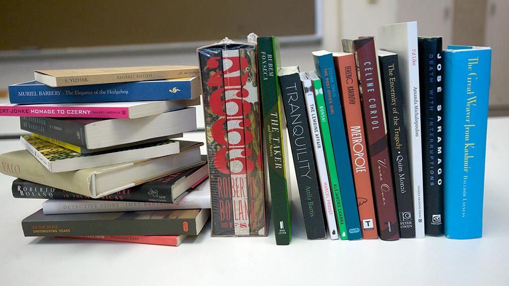A row of books on a table with the spines facing out.