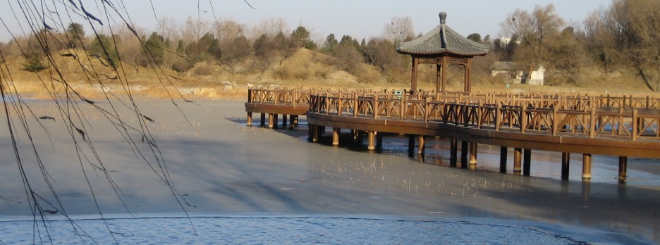 A landscape in China showing a walking bridge and gazebo over water.