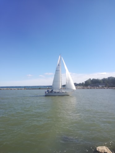sail boat on water with blue sky