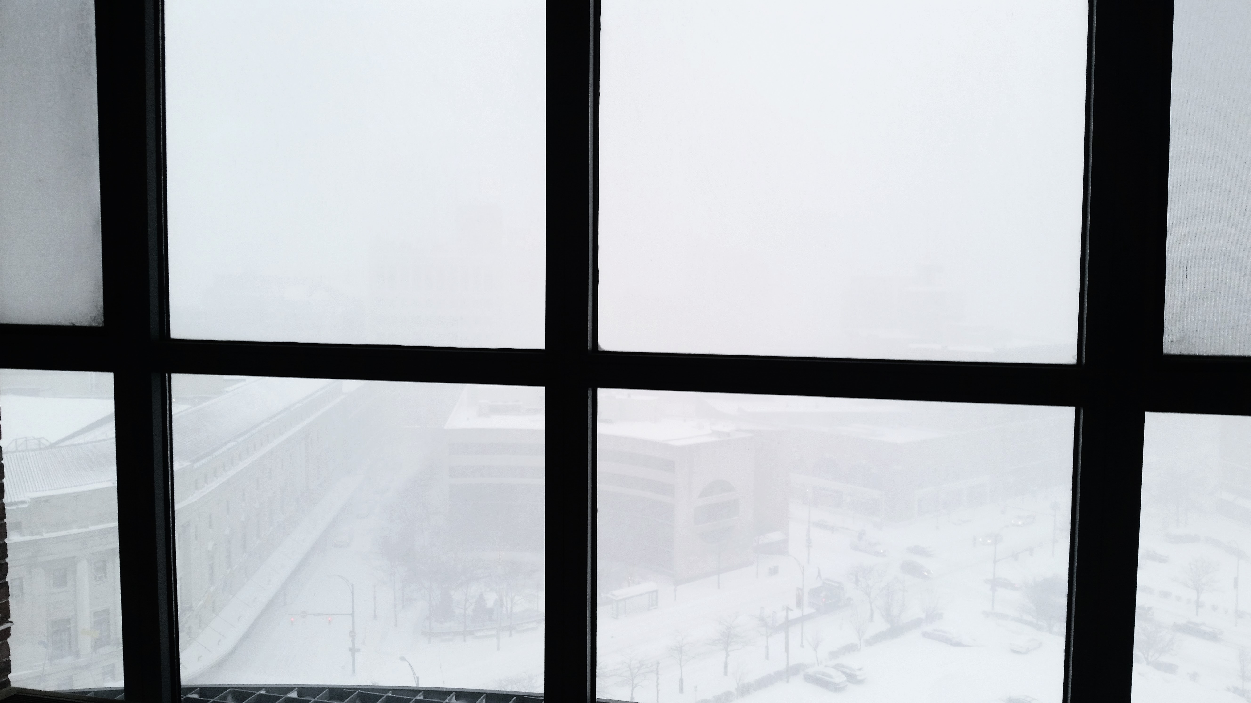 view from a window of eastman theater and surrounding area in a snow white-out