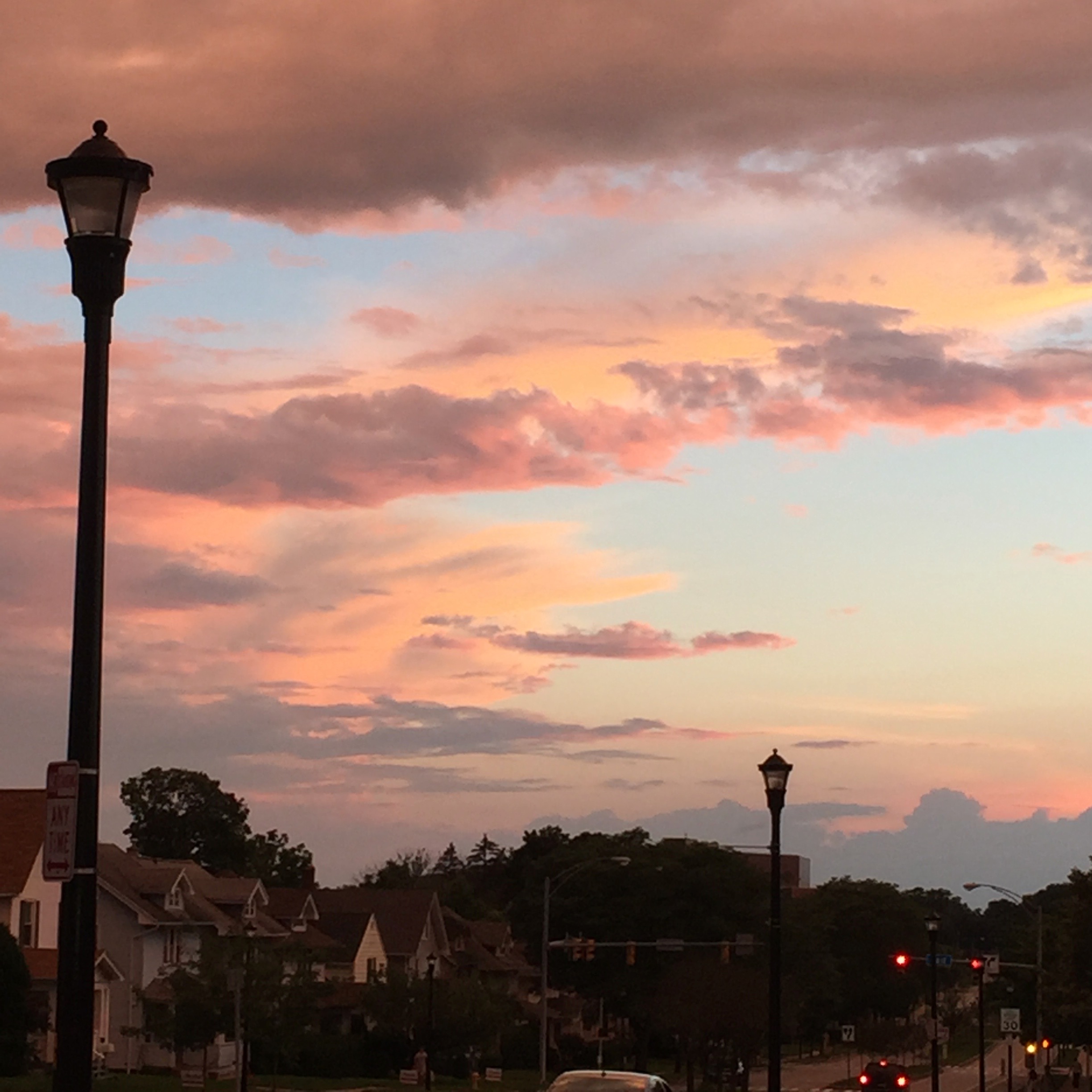 sunset silhouetting a street of houses with a lamp-post in the foreground 