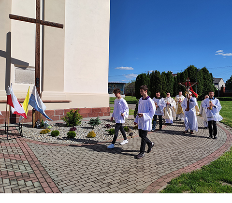 A group of altar boys walking towards a church.