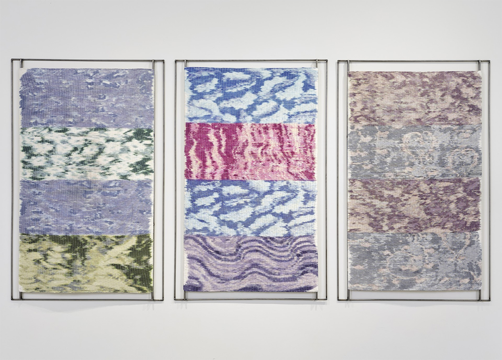 Three vertical textiles in various colors.