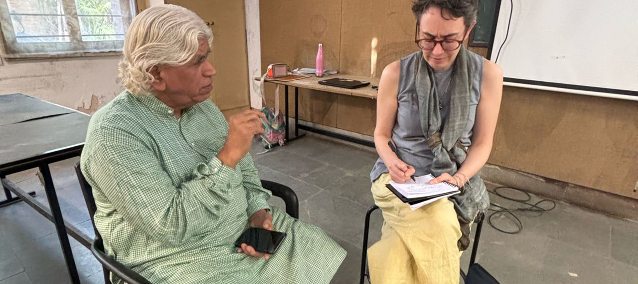 Two people sitting in a classroom having a conversation.