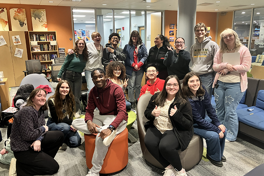 A large group poses for a picture while gathered together for coffee.
