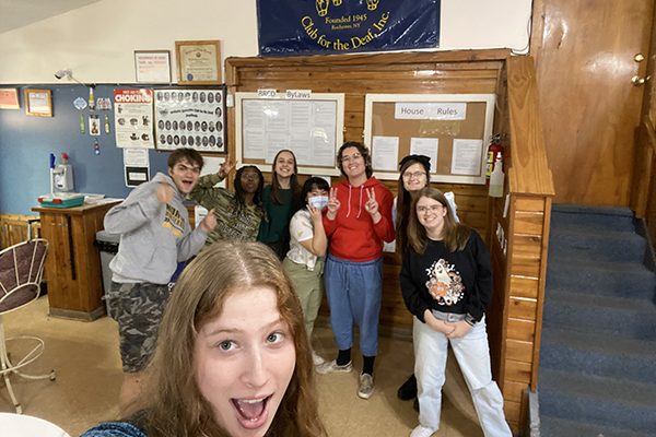 A group of students taking a selfie in a classroom.