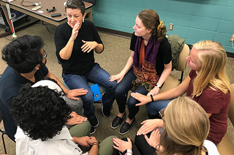 A class of students communicating with ASL.