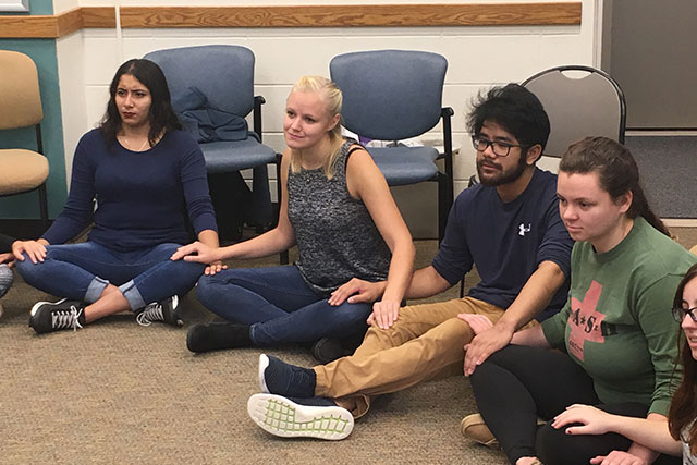 A group of students sitting on the floor.