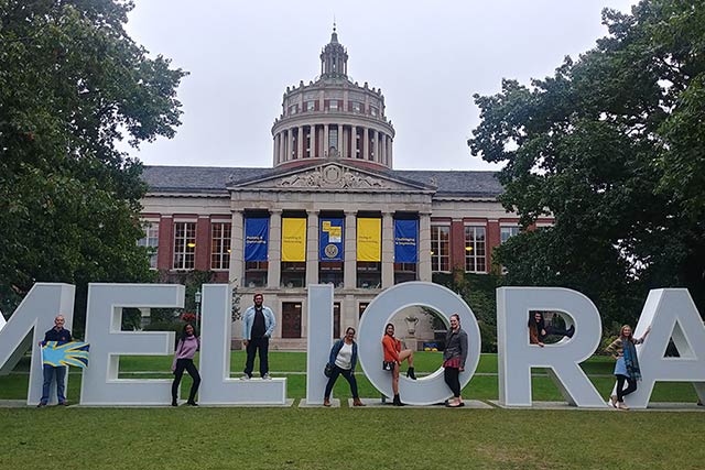 People posing with large white letters that spell Melinda.