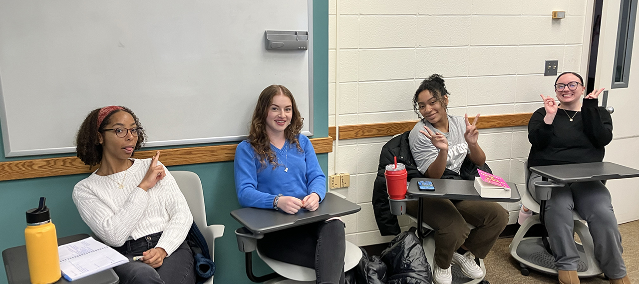 Four students signing in class.