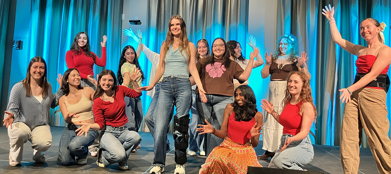 A group of performers pose on stage.