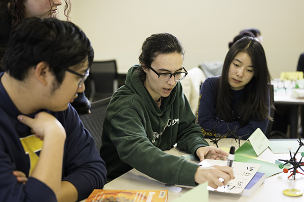 A student leading a discussion with other students.