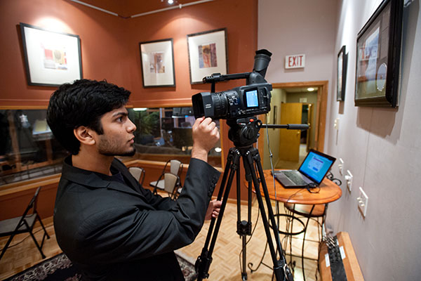 A student focusing a video camera.