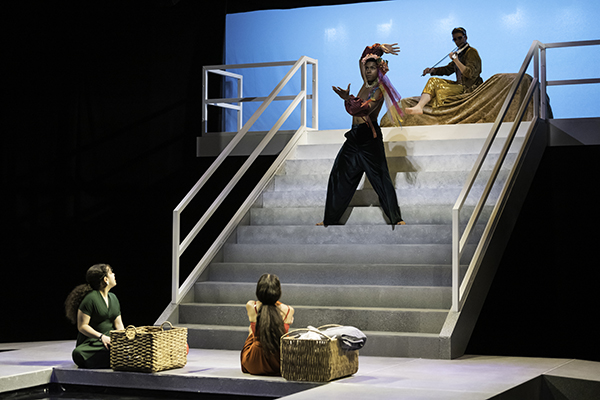 Students during a performance acting on a darkened stage.