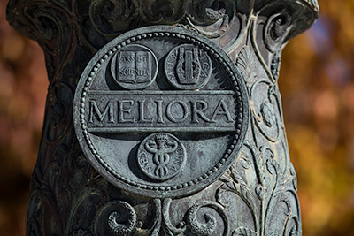 The Meliora shield on a lamppost in the Eastman Quad.