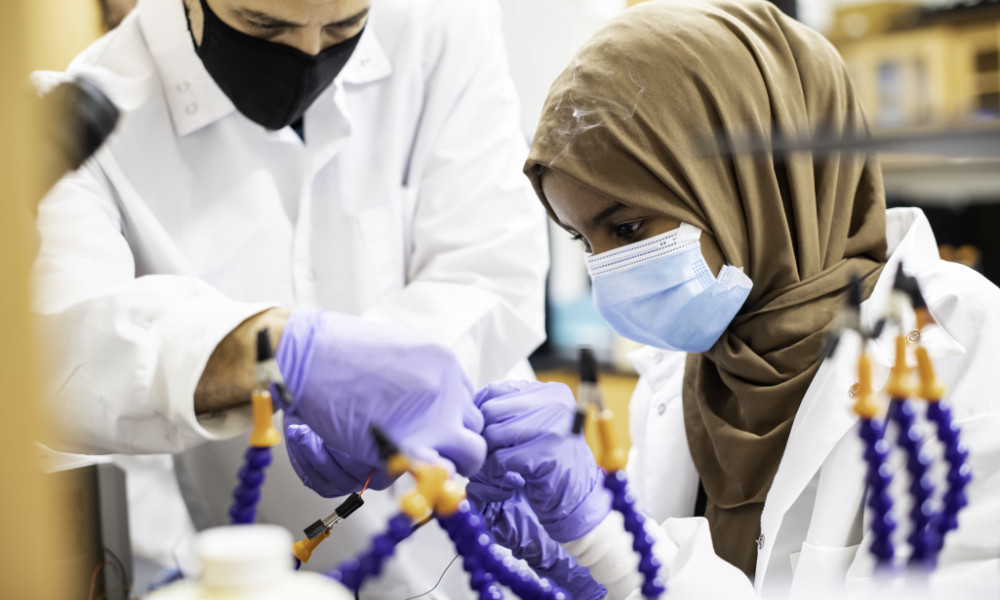 High school student practices soldering to repair an experiment component