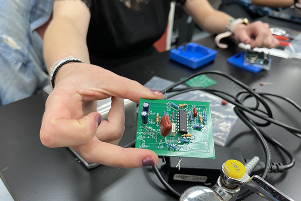 Student's hand holds part of an innovative sepsis diagnosis device.