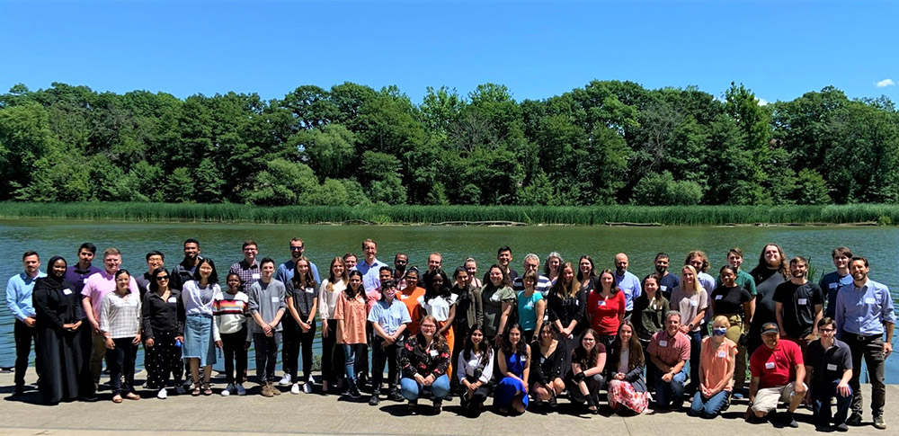 Retreat attendees pose for a photo outside by the water.