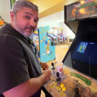 Daniel Colon playing a ninja turtles arcade game. 
