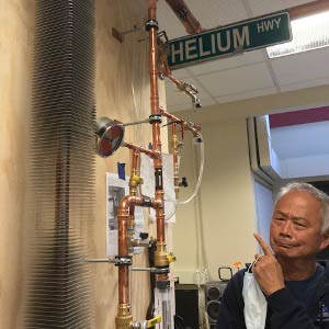 Ray Teng standing under a Helium HWY sign.