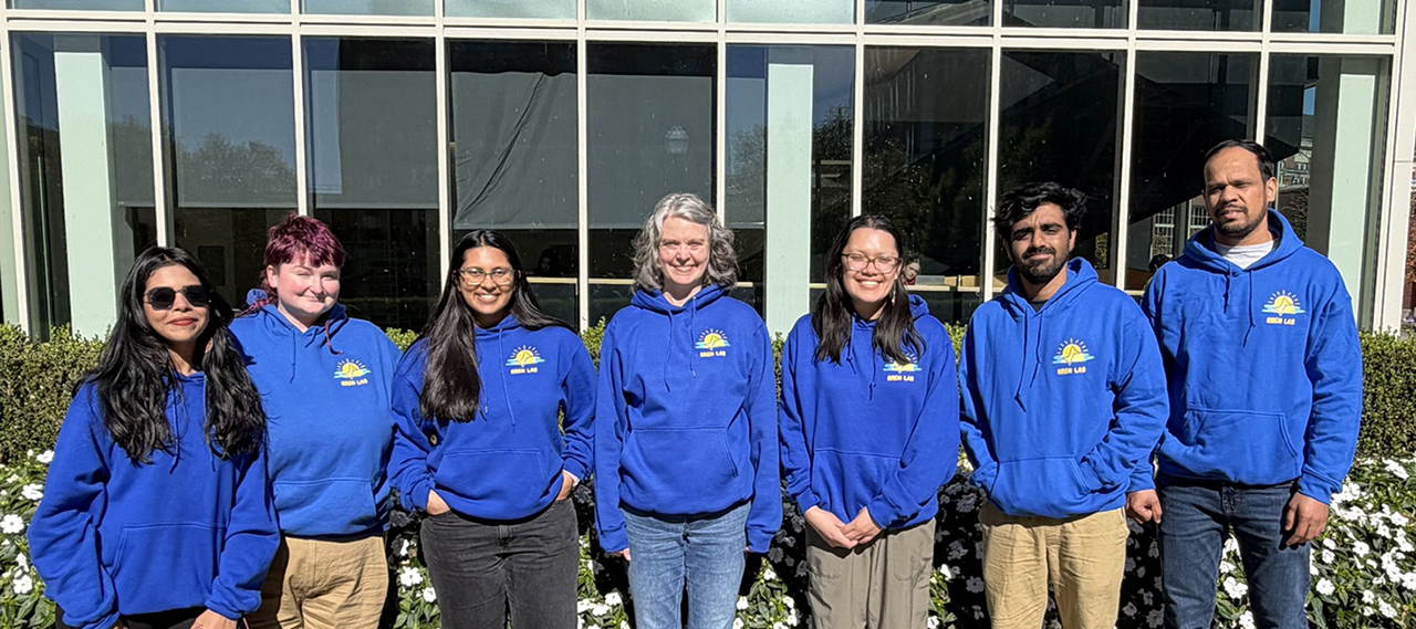 A group of members from 2026 smiling as they pose for the camera in front of a building.
