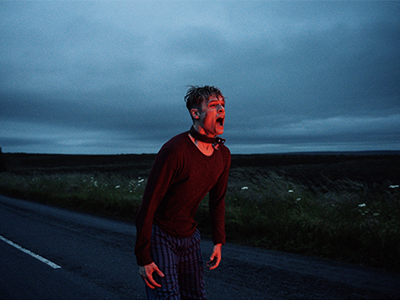 A still image from the film of a man screaming.