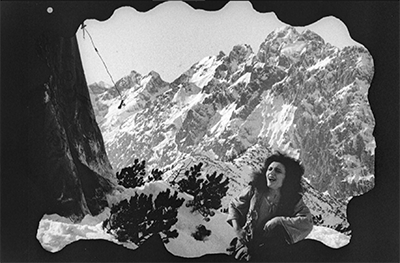 A still image from the film of a person sining with a mountain in the background.