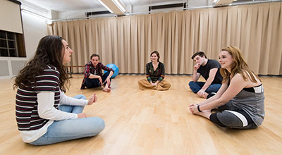 Students sitting in a circle on the floor.