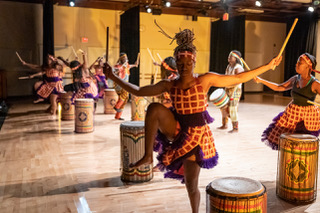 Dancers dancing on stage in costume.