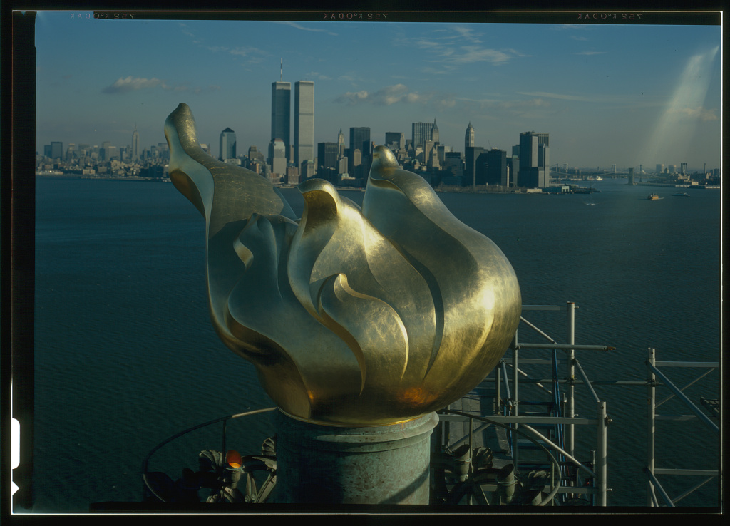 Statue of liberty flame with lower Manhattan in distant background