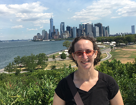 Karen Berger standing outside with a cityscape in the background.