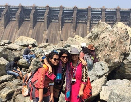 Sumana Roy posing with friends at a dam.