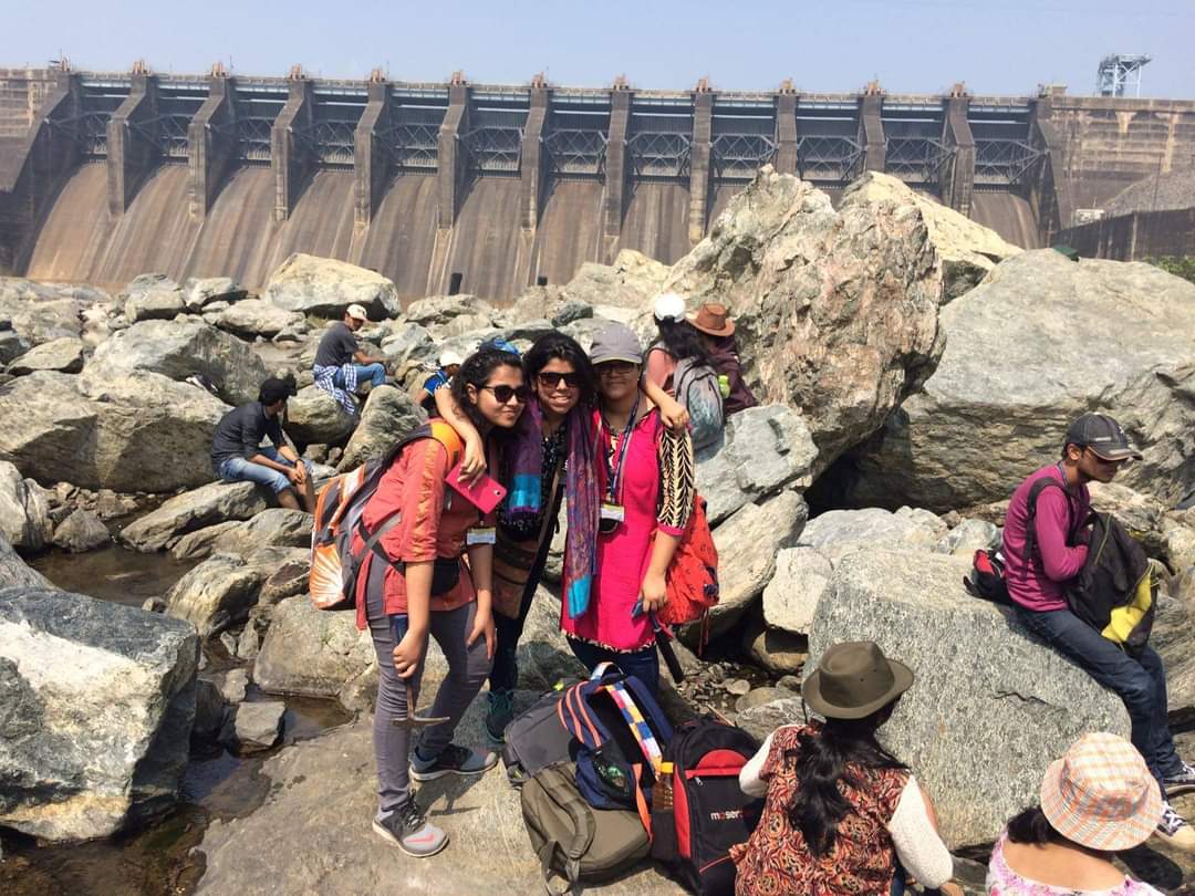 Sumana Roy is posing with friends at a dam.