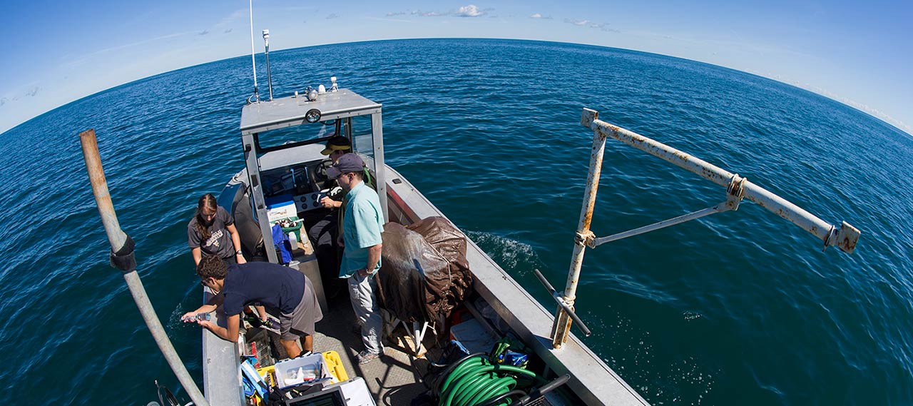 Professor and students on a boat on Lake Ontario