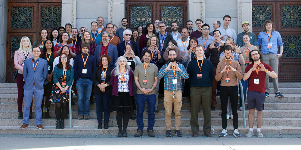 A group photo of the organizers standing on the steps of Rush Rhees Library.