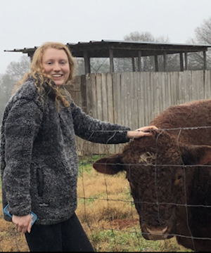 Anna Langer petting a cow.