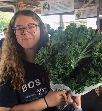 Leah holding a bunch of kale.